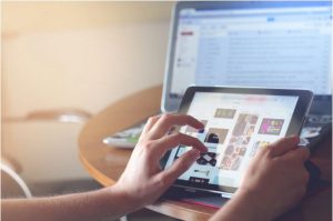 Hands browsing products on a tablet