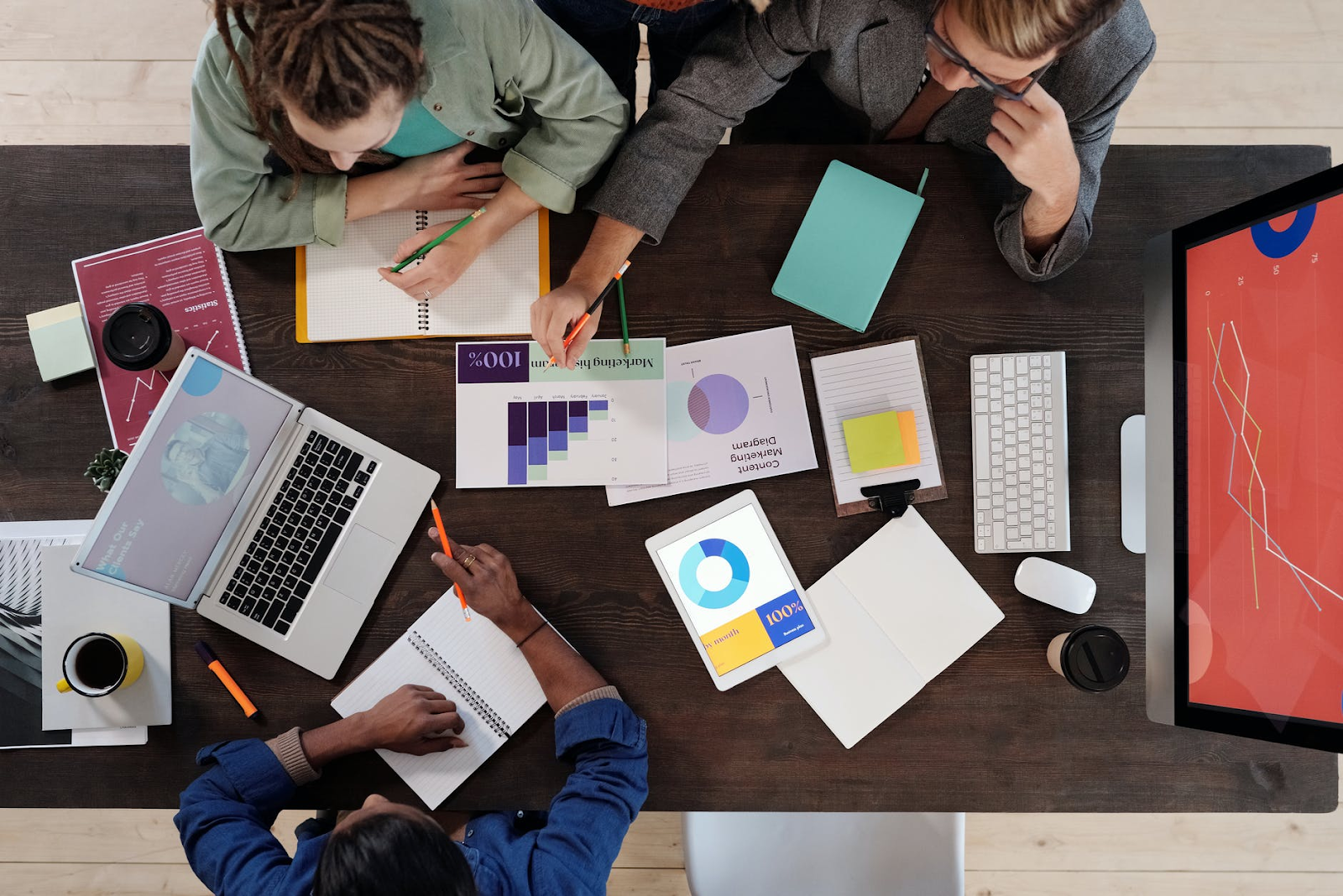 employees gathered at a table reviewing data charts